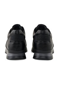 Black leather sneakers with padded collar, textured black heel tabs, and a rugged sole. Features subtle branding on back.