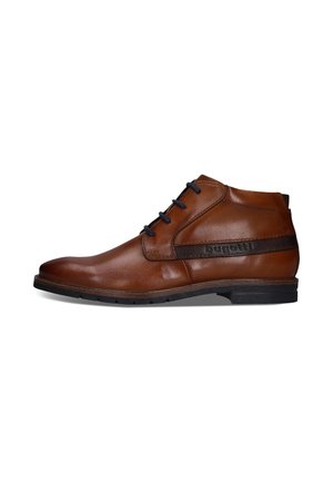 Brauner Leder-Herren-Knöchelstiefel mit schwarzen Schnürsenkeln und einem schwarz vernähten Streifendetail über der Sohle auf weißem Hintergrund.