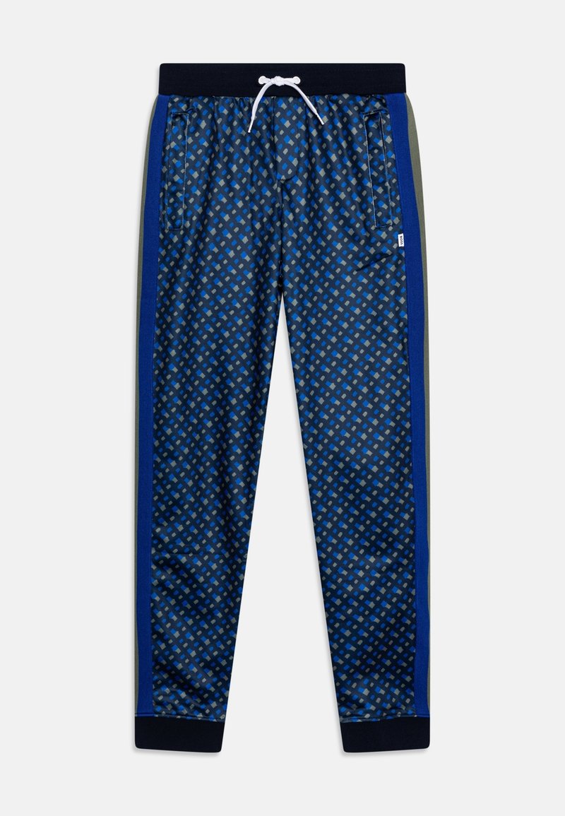 Námořnické tepláky s geometrickým vzorem v odstínech modré. Mají elastický pas, šňůrku a postranní kapsy. Doplňují je zelené boční pruhy.