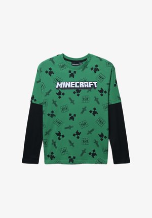 T-shirt verde a maniche lunghe di Minecraft con grafiche pixelate nere, tra cui strumenti e personaggi, con il testo "MINECRAFT" ben in evidenza.
