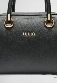 Sort struktureret læderhandtaske med hardware i guld tone, der har en toprem og mærkenavnet "LIU·JO" præget på forsiden.