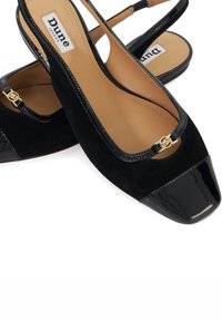 Black suede slingback shoes with a glossy black toe cap, gold hardware accent, and a cushioned beige interior. Flat heel design.