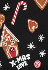 Schwarzer Stoff mit bunten Strickmustern eines Lebkuchenhauses, Zuckerstange, Herzen, Schneeflocken und dem Text "X-MAS LOVE".