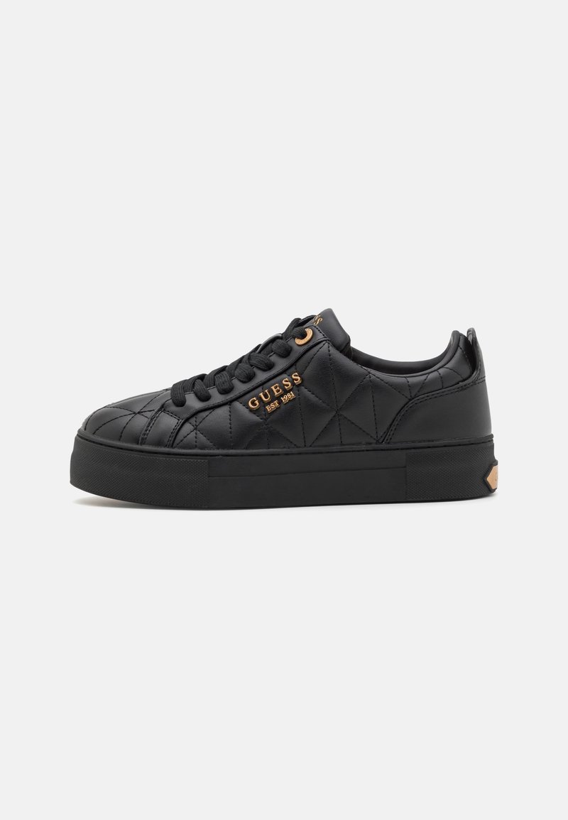 Sorte quilted sneakers med en flad gummisål, udstyret med sorte snørebånd, guld accenter og et logo på siden.