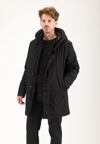 Parka nera imbottita con cappuccio, zip frontale, bottoni a pressione e tasche laterali. Presenta una fodera interna a trama morbida.
