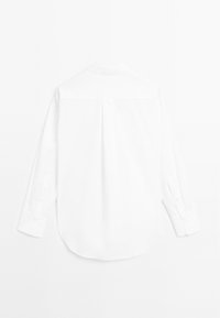 Hvid skjorte med lange ærmer, bagtil med plissé, klassisk krave, knapmanchetter og rundet kant. Glat tekstur og minimalistisk design.