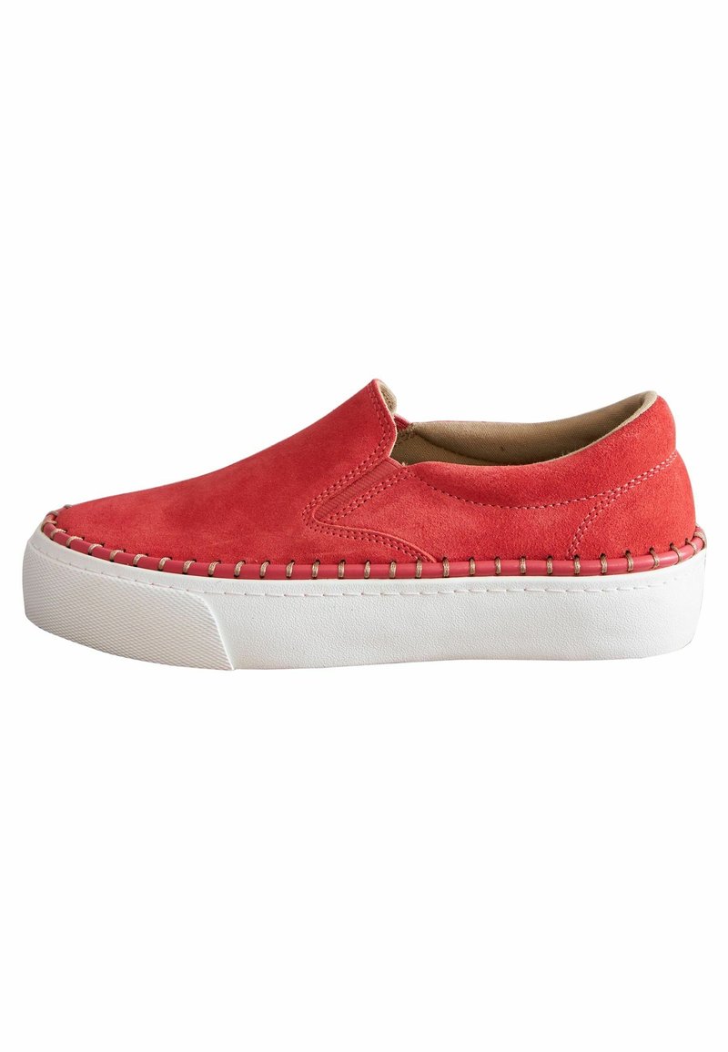 Chaussures en daim rouge à enfiler avec une semelle blanche épaisse, présentant des détails cousus le long du bord supérieur et une doublure intérieure lisse.