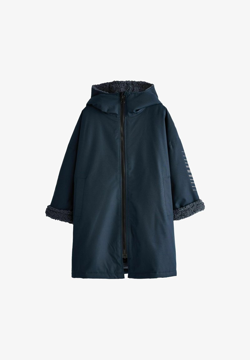 Navy blue oversized coat with a zip front, hood, and textured fur lining at the collar and cuffs. Features side pockets and minimal stripes.