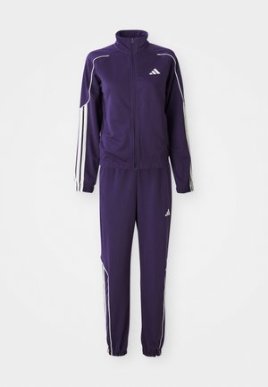 Tuta viola con giacca a zip e strisce bianche e pantaloni coordinati. Realizzata in tessuto morbido con polsini e vita elasticizzati.