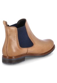 Bottine Chelsea en cuir marron avec des panneaux latéraux élastiques navy, bout rond et talon bas empilé. Texture lisse et semelle en caoutchouc durable.