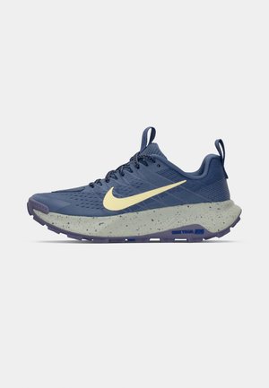 Běžecké boty Nike na trať v tmavě modré barvě s světle žlutým logem Swoosh, šedou skvrnitou mezipodešví, texturovaným svrškem a odolnou gumovou podešví.