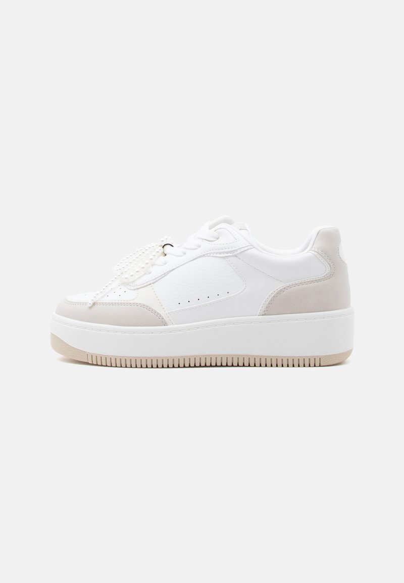 Baskets de sport blanches avec accents beige, dotées d'une tige en cuir texturé et textile, bout rond, et semelle épaisse en caoutchouc.