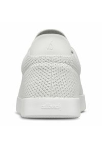 Valkoinen lenkkari, jossa on teksturoitu, hengittävä verkkopäällinen ja kiinteä valkoinen kumipohja. Mallissa on pyöristetty kanta ja hillitty brändäys kantalapussa.