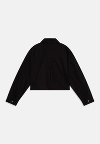 Chemise noire recadrée avec un col, des manches longues et des poignets à boutons. Tissu lisse avec un détail de dos.