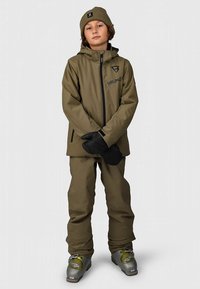 Kaki smučarska jakna in hlače z logotipom, črne rokavice in ujemajoča se kapa. Obleka ima gladko, sijočo teksturo in praktičen dizajn.