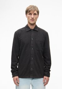 Σκούρο γκρι πουκάμισο με γιακά, μία τσέπη στο στήθος και μακριά μανίκια. Κατασκευασμένο από υφή υφάσματος με μπλε κουμπιά.