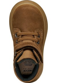 Zapato de ante marrón con punta redonda, cordones texturizados, detalles cosidos y suela de goma ligera. El interior cuenta con un forro suave para mayor comodidad.