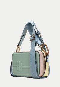 Obdélníková crossbody taška v mátově zelené, růžové a žluté kůži. Má polstrovaný design, modrý popruh a zlaté kovové detaily.