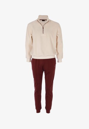 Pullover in pile color crema con zip a quattro punti e logo ricamato; abbinato a pantaloni della tuta color bordeaux con taglio affusolato, cuciture laterali e tasche.