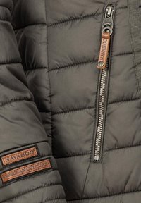 Dark gray puffer jacket with horizontal stitching, featuring a silver zipper and leather tags with "Navahoo" and "American Culture" embossed.