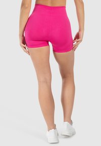 Hogewaisted, strakke roze shorts gemaakt van rekbare stof; gladde textuur zonder zichtbare patronen of accenten.