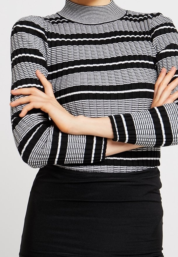 Col roulé côtelé à rayures noires et blanches, silhouette ajustée et manches longues. Tissu texturé avec lignes horizontales et verticales.