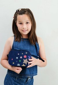 Borsa in denim blu navy con decorazioni a forma di stella multicolore. La borsa è dotata di chiusura con zip e di una tracolla per il trasporto.