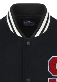Marineblauwe wollen varsityjacket met een geribbelde kraag met witte strepen, zwarte drukknoopjes en een groot rood en wit letterpatch op de voorkant.
