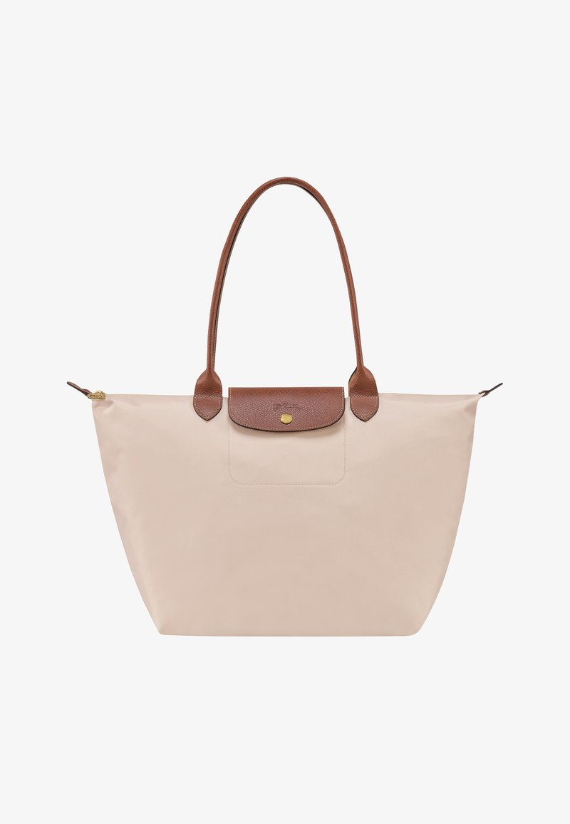 Beige tote bag with a structured design, leather handles, and a flap closure featuring a gold button. Smooth texture with a minimalist aesthetic.