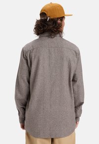 Bruine, gestructureerde, longsleeve shirt met een puntige kraag, knoopmanchetten en een afgeronde zoom. Het achteraanzicht toont een eenvoudige uitstraling.