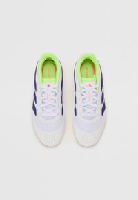 Zapatillas deportivas moradas y blancas con material de malla, superficie texturizada y acentos en verde neón en el interior. Diseño de cordones con puntera perforada.