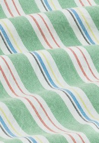 Tessuto intrecciato con sfondo verde testurizzato e strisce orizzontali bianche caratterizzate da linee più sottili rosse, nere, blu e gialle, mostrato con pieghe morbide.