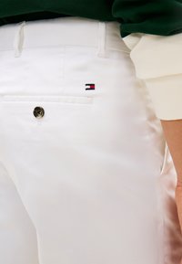 Λευκό βαμβακερό παντελόνι με ομαλή υφή, διακοσμημένο με μία πίσω τσέπη και ένα μικρό κεντητό λογότυπο σε κόκκινο, λευκό και μπλε.