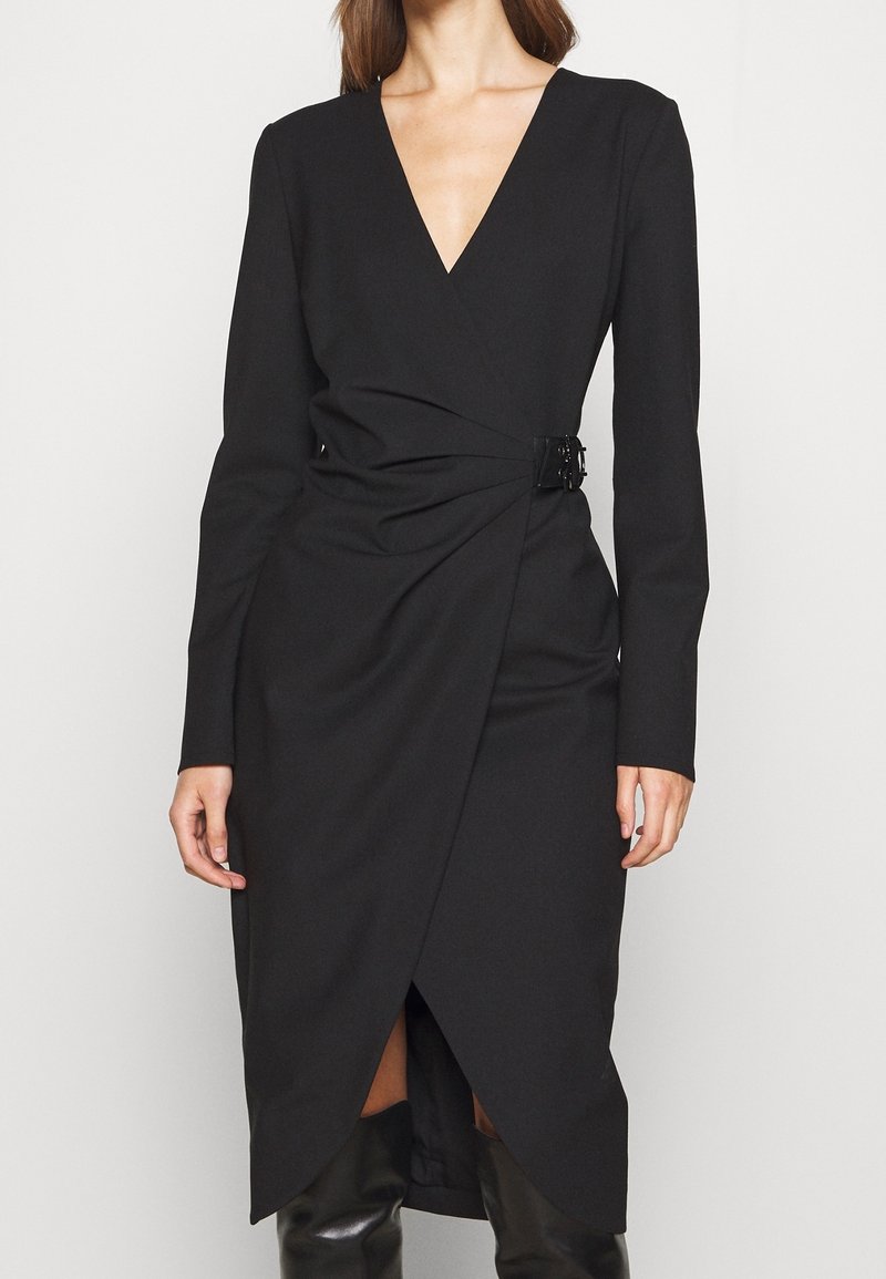 Schwarzes, langärmliges Wickelkleid mit tiefem V-Ausschnitt, das über ein verdrehtes Vorderteil und eine seitliche Schnalle verfügt, aus glattem Stoff gefertigt.