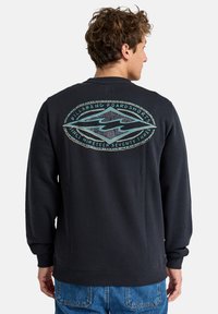 Black sweatshirt with a ribbed crew neck and cuffs. Features a large, colorful logo on the back. Made of soft fabric with a smooth texture.