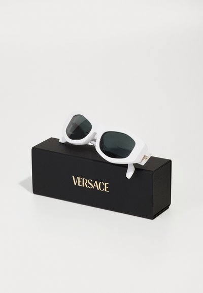 Valged ristkülikukujulised prillid tumedate läätsedega mustal karbil, mille esifooliumil on kuldne "VERSACE" logo. Sile, läikiv viimistlus.