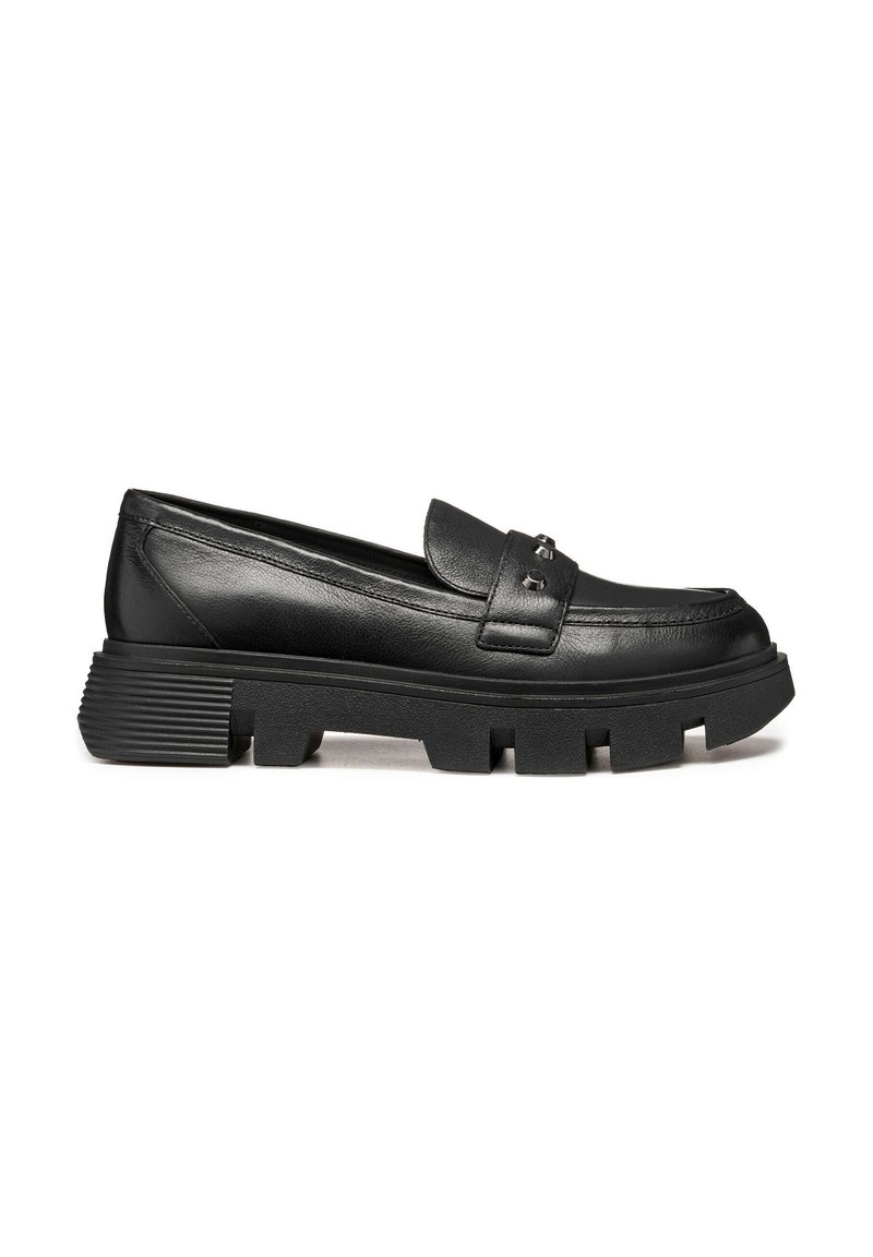 Mocasines de cuero negro con una suela plataforma bajo y gruesa, que presentan una correa decorativa y detalles metálicos en la parte frontal. Detalle texturizado en el tacón.