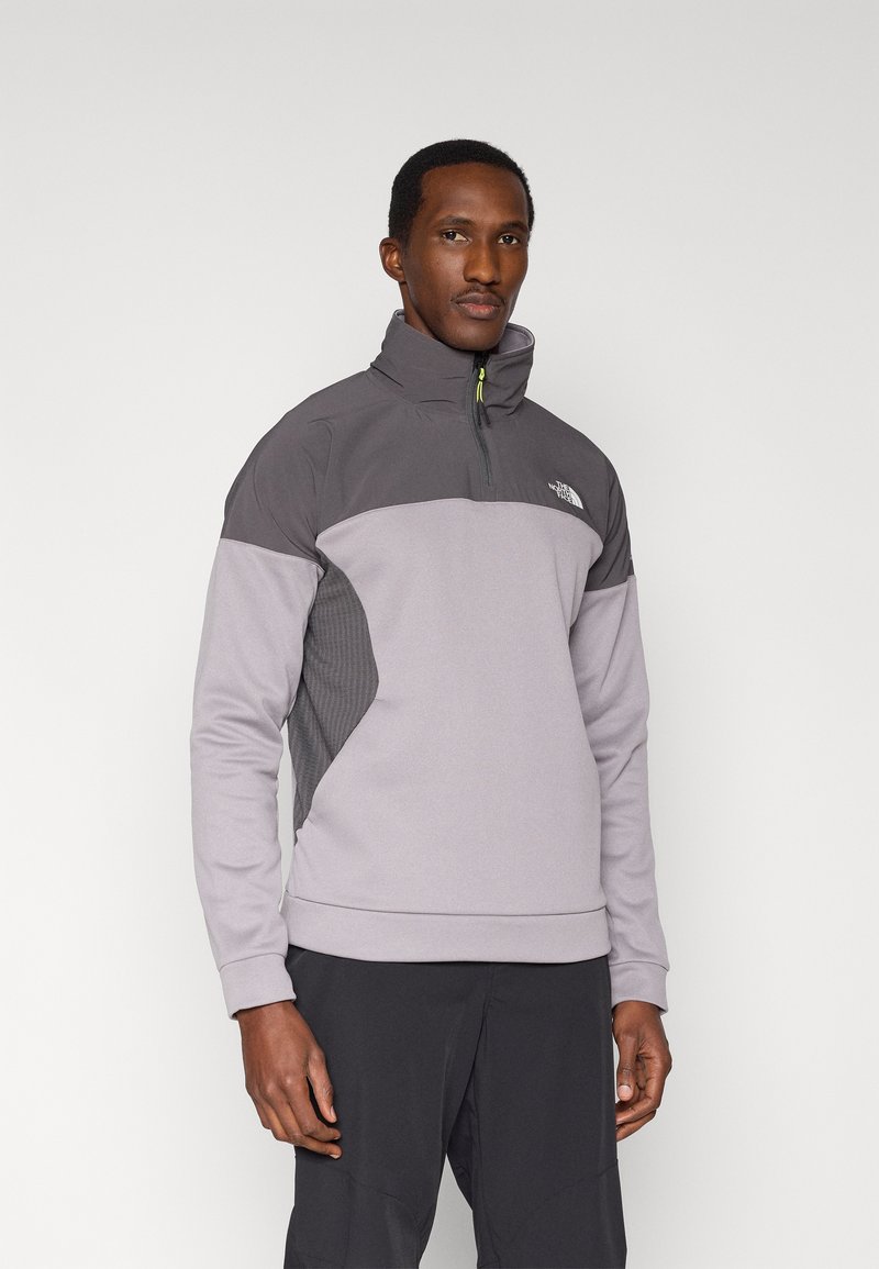 Gray quarter-zip sweatshirt with high collar, featuring a panel design and textured side details. Material appears soft and lightweight.