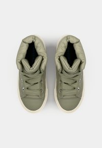 Olive green sneakers with puffy ankles, lace-up design, silver eyelets, and cream-colored rubber soles. Textured fabric upper.