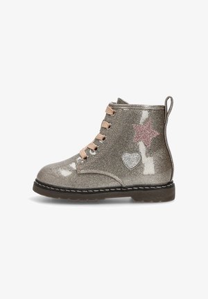 Botín brillante de plata con acentos de estrella y corazón en rosa. Presenta cordones beige, un acabado texturizado y una suela de goma negra.