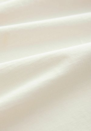 Tissu de couleur crème clair avec une texture lisse et douce. Des tissages visibles et subtils forment un motif uniforme sur la surface.
