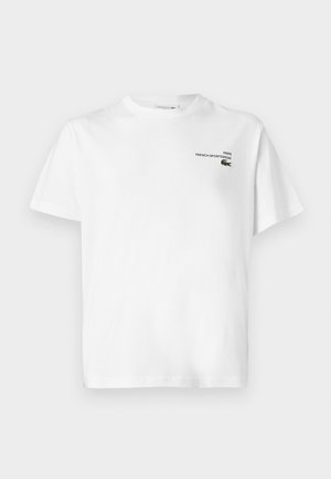 Balts kokvilnas T-krekls ar apaļu izgriezumu, īsām piedurknēm un nelielu melnu logotipu ar uzrakstu "PARĪZE FRANČU SPORTA APĢĒRBS." Klasiska piegriezuma; gluda tekstūra.