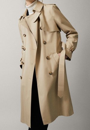 Cappotto trench beige realizzato in tessuto leggero, con design doppiopetto, dettagli dei bottoni e vita cinturata. Maniche lunghe e colletto.