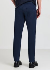 Navyblaue Jeanshose mit geradem Schnitt, fünf Taschen und einer glatten Textur. Abgeschlossen mit sichtbaren Nähten und ohne Verzierungen.