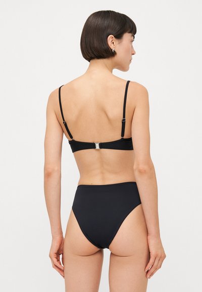 Schwarzes Bikini-Oberteil mit verstellbaren Trägern, schlichtem Design, matter Textur, Verschluss hinten und hochgeschnittenem Unterteil.