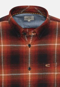 Rood en zwart geruite flanellen shirt met een knoop-down kraag, voorzien van zwarte knopen en een blauwe binnenkraagvoering. Etiket vermeldt "Camel Active."