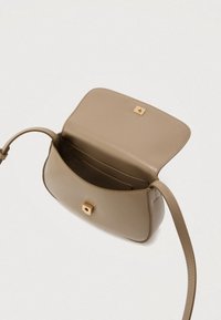 Handtasche aus hellbraunem Leder mit schlankem Design, einem goldfarbenen quadratischen Verschluss, einem verstellbaren Riemen und einer Innentasche. Die Öffnung zeigt eine glatte Oberfläche.