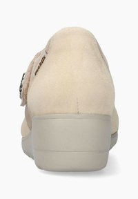 Zapato de ante beige con un respaldo redondeado, suela gris sólida y una correa decorativa con un acento plateado en el lado izquierdo.