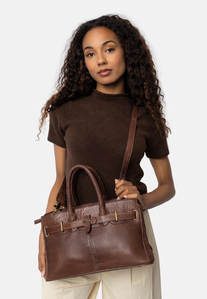 Brun läderhandväska med texturerad yta, dubbla handtag, en avtagbar rem och detaljer i guldfärg. Har en scalloped-detalj.