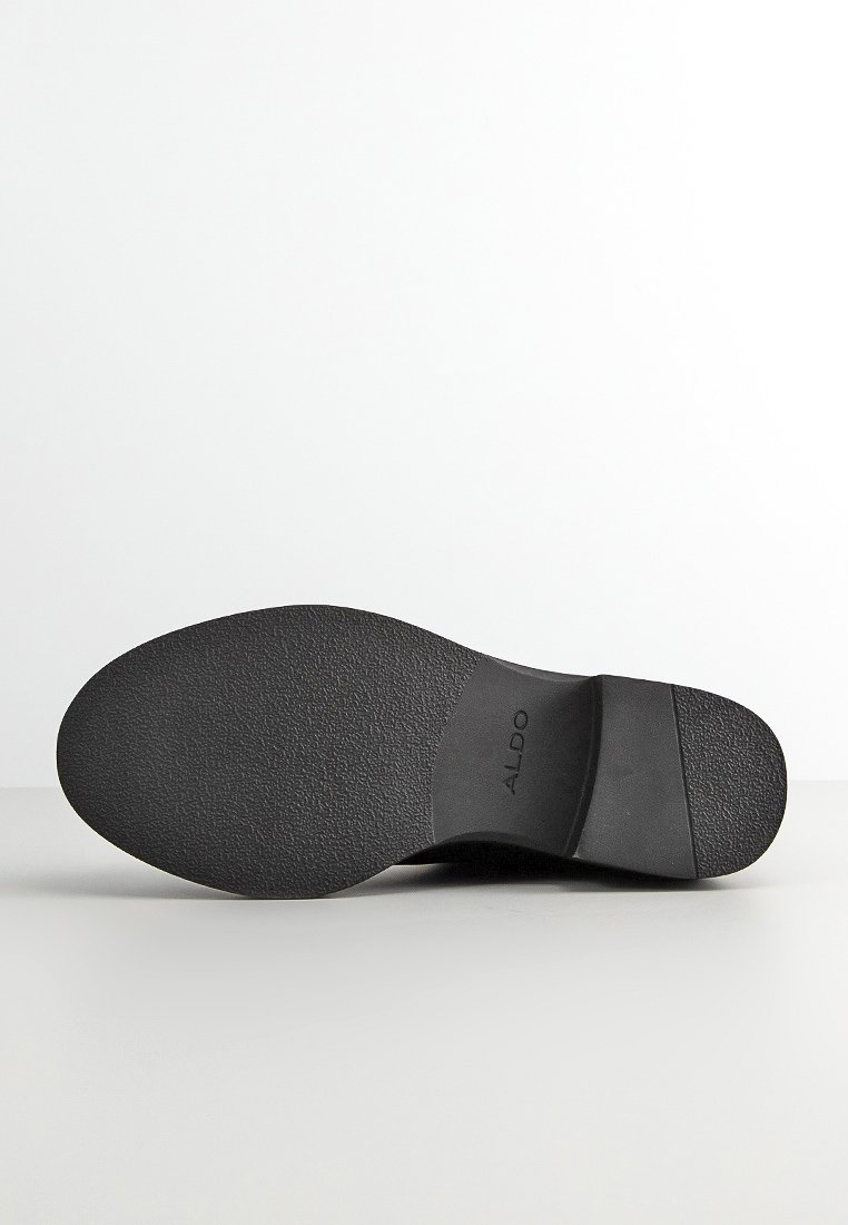 Suela de zapato negra con material de goma texturizado, con un leve tacón y el nombre de la marca "ALDO" grabado en el lateral.